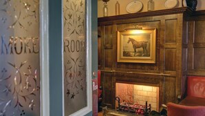 A room with a fireplace, a framed picture of a horse, and a decorative metal tray with ornaments. - The Bell In Driffield (Driffield)