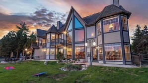 A multi-story house with a balcony, large windows, and a well-maintained lawn. - Big Bear Lakefront Luxury Home w/ Spa & Views (Big Bear Lake)