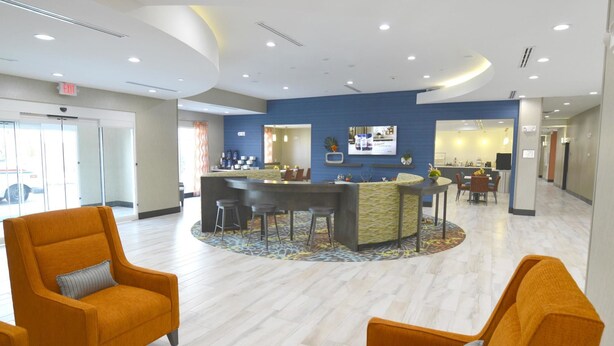 A hotel lobby with a reception desk, seating area, and a view of the outside. - Best Western Plus Pasadena Inn & Suites (Pasadena)
