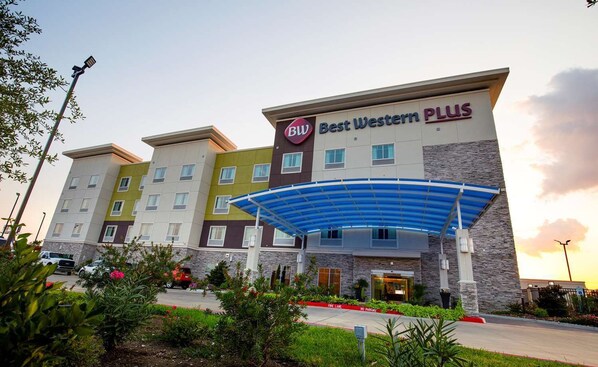 Ett Best Western Plus-hotell med en inglasad entré, flera våningar och en parkeringsplats.