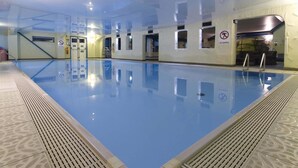 An indoor swimming pool with clear water, tiled walls, and a no running sign. - Park Hall Hotel (Chorley)