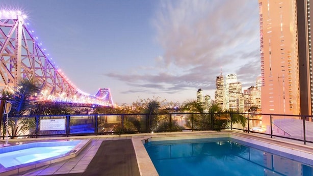 A rooftop pool with a city skyline view, a bridge with lights, and a sign that reads 'SPA'. - Oakwood Hotel and Apartments Brisbane (Brisbane)