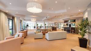 A spacious hotel lobby with multiple seating areas, a central dining space, and a kitchen area. - Oakwood Hotel and Apartments Brisbane (Brisbane)