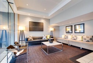 A modern living room with a sofa, coffee table, and lamps. - Oakwood Hotel and Apartments Brisbane (Brisbane)