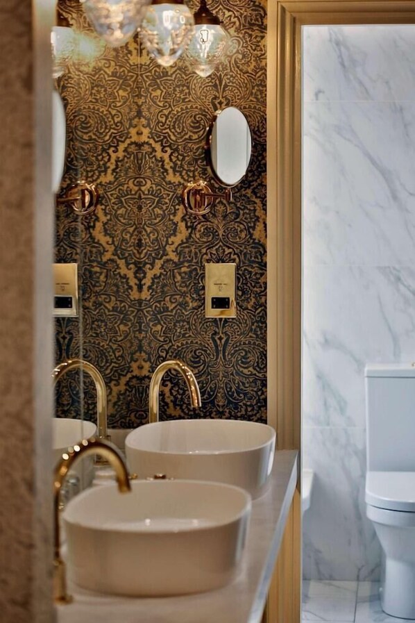 A bathroom with two sinks, a mirror, and a toilet. - CBH Oaklands Hall Hotel (Grimsby)