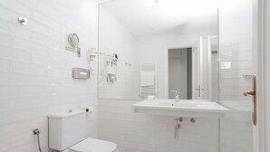 A modern bathroom with a toilet, bidet, and sink. - Sonder Santa Ana (Madrid)