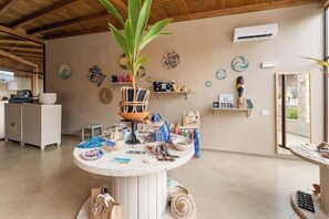 Ein Zimmer mit einem runden Tisch in der Mitte, der verschiedene Gegenstände zeigt, einem Deckenventilator und Wandverzierungen.