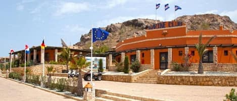 A building with a sign reading 'MARINE CLUB' and multiple flags, including the European Union flag.