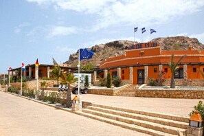 A building with a sign reading 'MARINE CLUB' and multiple flags, including the European Union flag. - Ahg Marine Club Beach Resort (Boa Vista)