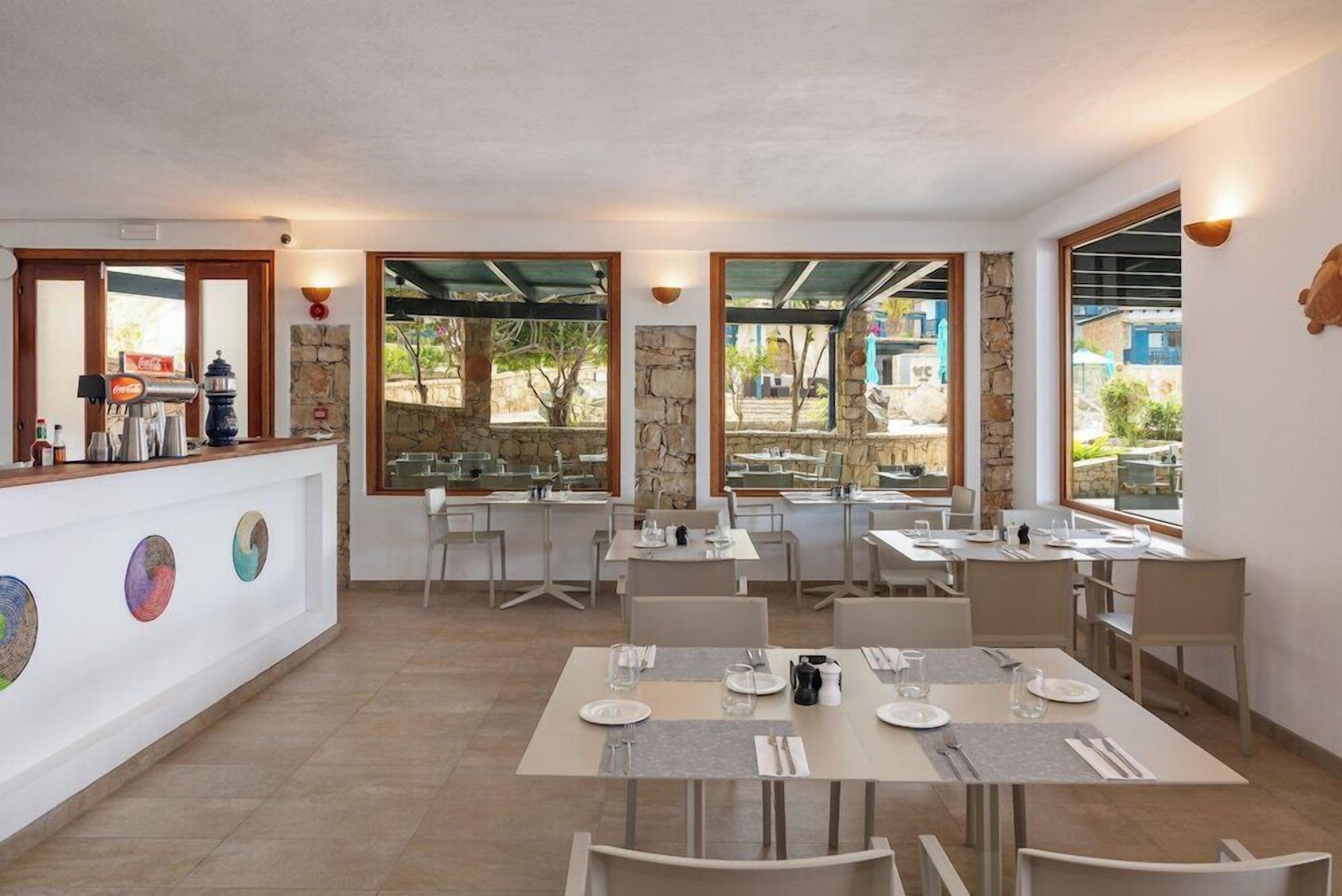A restaurant with outdoor seating, stone walls, and a Coca-Cola branded coffee machine.