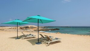 A beach with two turquoise umbrellas and lounge chairs. - Ahg Marine Club Beach Resort (Boa Vista)