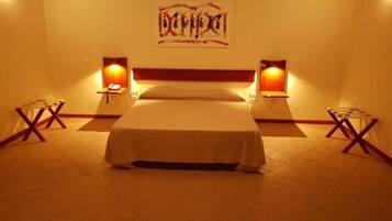 A hotel room with a bed, bedside lamps, and a wall-mounted artwork.