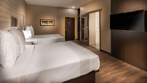 A hotel room with two beds, a TV, a wardrobe, and a door leading to a bathroom. - Glo Best Western Lexington (Lexington)