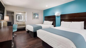 A hotel room with two beds, a desk, a mirror, and a bathroom. - Laredo Hotel (Laredo)