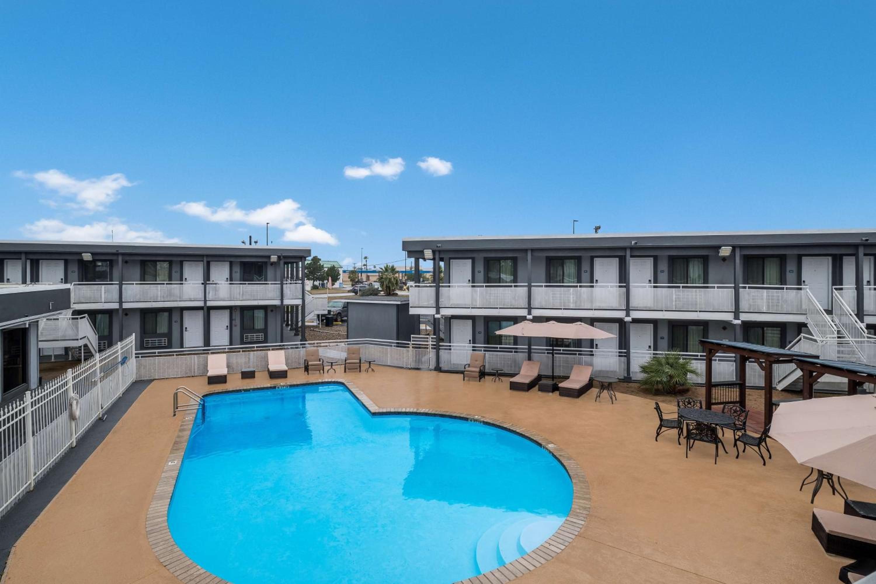 Ein Hotel mit Swimmingpool, Außenbereich und blauem Himmel.