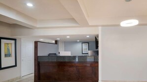 A modern kitchen with a dark wooden island, recessed ceiling lights, and a white door. - Laredo Hotel (Laredo)