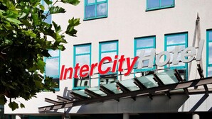 A building with a sign that reads 'InterCity Hotel' with multiple windows and a tree in the foreground. - Intercityhotel Kassel (Kassel)