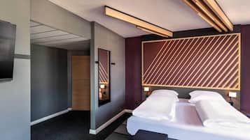 Ein modernes Hotelzimmer mit einem großen Bett, einem Flachbildfernseher und einem einzigartigen, geometrischen Wanddesign.