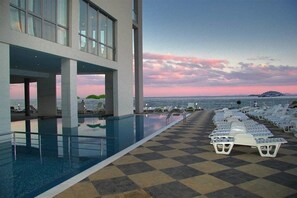 A poolside area with lounge chairs and a view of the ocean. - Hotel Moonlight Path (Nessebar)