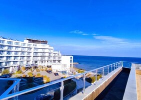 Un hotel con piscina, vistas al mar y un balcón.