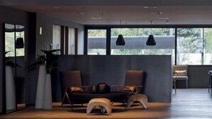 A modern hotel lobby with a reception desk, seating area, and large windows. - Casasur Pilar Hotel (La Lonja)
