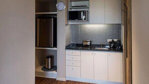 A compact kitchen with a stainless steel refrigerator, microwave, and toaster. - Casasur Pilar Hotel (La Lonja)