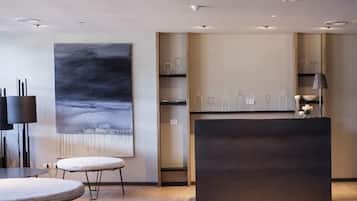 Een modern interieur met een receptiebalie, een groot abstract schilderij en een minimalistisch design.
