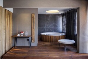 Ein modernes Badezimmer mit einem Holzbadschrank, einer runden Badewanne und einem kleinen Hocker.