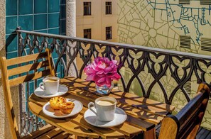 A balcony with a wooden table, two chairs, a flower vase, and a map on the wall. - Opulent Historic Palace Suite w/ Terrace Overlooking Porto’s Historic Center 1J (Porto)
