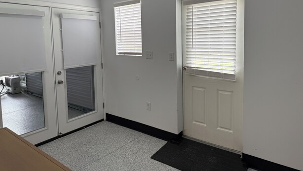 A hallway with two doors, a window, and a doorbell. - Cozy 1-bedroom cottage in serene Ravenel with AC (Ravenel)