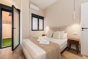 Ein Schlafzimmer mit einem Bett, einem Nachttisch, einem Fenster und einer Klimaanlage.