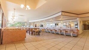 A spacious hotel lobby with a central bar area, seating arrangements, and a large window providing natural light. - Clarion Hotel Bakersfield North (Bakersfield)