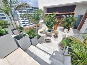 A rooftop terrace with outdoor seating, potted plants, and a view of surrounding buildings. - New studio apartment in front of the marina! (Santa Marta)