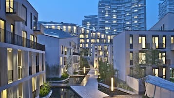A modern urban residential area with contemporary architecture, a central water feature, and well-lit pathways.
