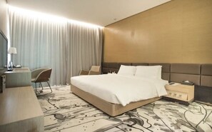 A hotel room with a large bed, bedside tables, a desk with a chair, and a large window with curtains. - CM+ Serviced Apartment Shenzhen Hillside (Shenzhen)