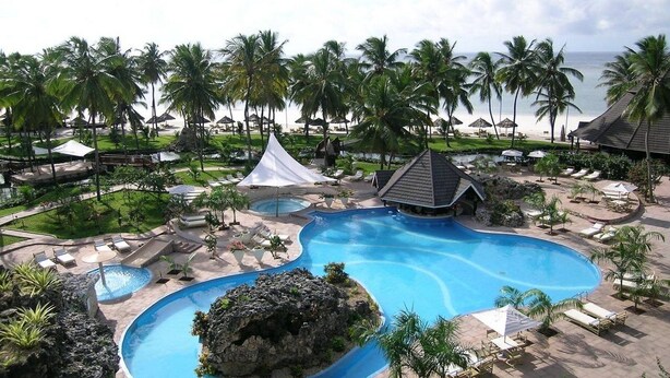 A resort with a large pool, palm trees, and beach views. - Diani Reef Beach Resort and Spa (Diani Beach)