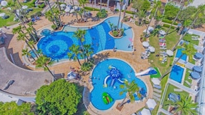 A resort with multiple swimming pools, palm trees, and lounge areas. - Dome Beach Marina Hotel and Resort (Ayia Napa)
