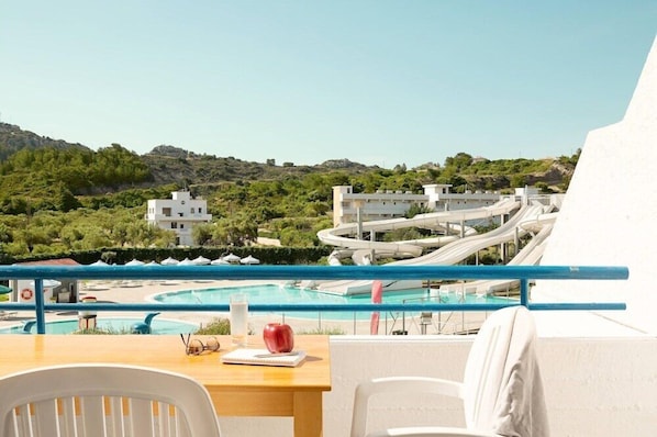 A balcony with a view of a water park, a pool, and buildings in the background. - Cyprotel Faliraki Hotel (Rhodes)