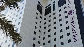 A modern hotel building with a prominent 'Premier Inn' sign, featuring a geometric facade and multiple balconies.
