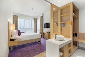 A hotel room with a bed, desk, TV, and a bathroom with a sink and mirror. - Premier Inn Dubai Ibn Battuta Mall (Dubai)