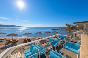 A beachside lounge with sun loungers and umbrellas, overlooking the sea. - Sunrise Beach Resort (Rhodes)