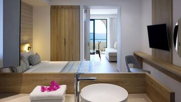 A modern hotel room with a large bed, a round white sink, a wooden vanity, a flat-screen TV, and a balcony with a view.