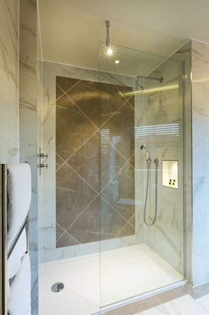 A glass-enclosed shower with a control panel, marble walls, and a tiled floor. - Down Hall Hotel Spa & Estate (Bishop's Stortford)