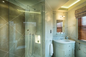 A modern bathroom with a glass-enclosed shower, a vanity with a mirror, and a window with blinds. - Down Hall Hotel Spa & Estate (Bishop's Stortford)