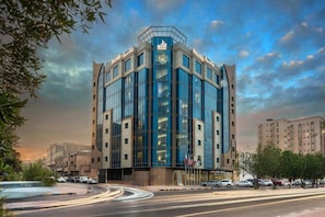 Un bâtiment moderne doté d’une façade en verre, de plusieurs étages et d’une entrée imposante.