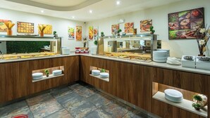 A buffet area with multiple serving stations, a green wall, and artwork on the walls. - BSA Gradina Hotel & Aquapark (Varna)