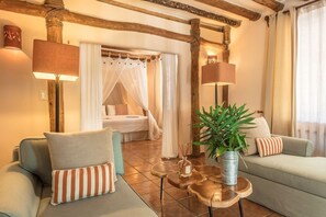 A cozy room with a bed, a sofa, a coffee table, and a potted plant. - Ser Casasandra Boutique Hotel (Isla Holbox)