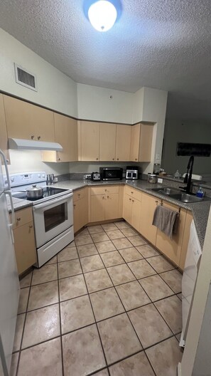 A kitchen with a stove, microwave, and sink.