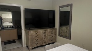 A bedroom with a bed, a dresser, a television, and a ceiling fan. - Spacious 3-bedroom condo in charming Royal Palm Beach with AC (Royal Palm Beach)