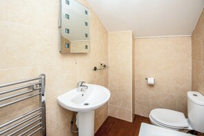 A bathroom with a sink, mirror, toilet, and a towel rack. - The Regency, Clifton Bristol (Bristol)